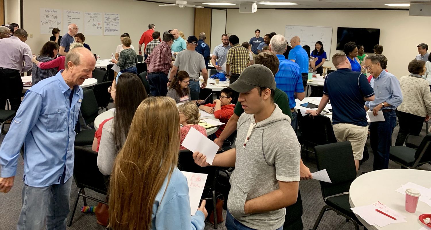 A full room of people practicing gospel conversations during training